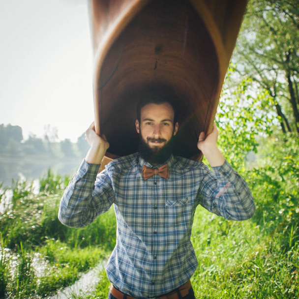 handsome man holding canoe  - Foto, imagen