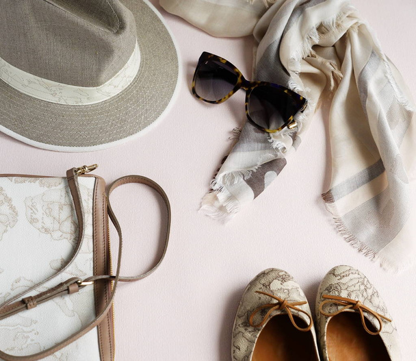 flache Lageset luxuriöser Damenkleidung und Accessoires in Pastellfarben Schal, Tasche, Schuhe, Hut und Sonnenbrille auf hellem Hintergrund. Ansicht von oben - Foto, Bild