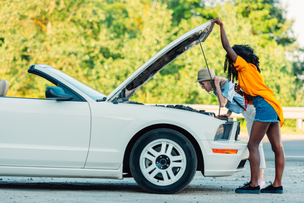 multiethnic women standing near broken car - Foto, immagini