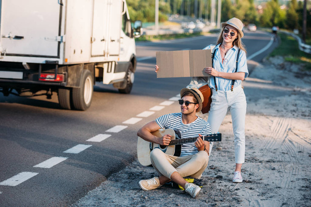 couple hitchhiking together - 写真・画像