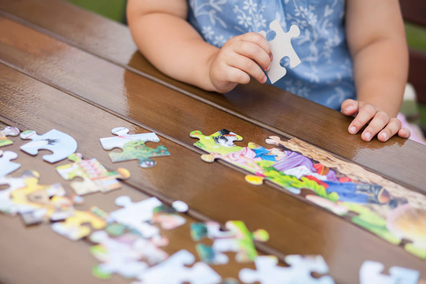 Child playing with puzzle. Child's hands closeup  - Photo, Image