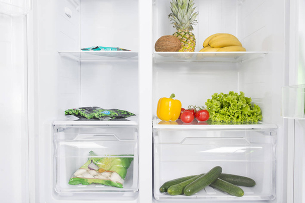 Open fridge full of fresh fruits and vegetables - Фото, зображення