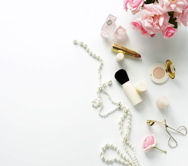 Flat lay, top view feminine desk, female make up accessories and bouquet roses.Beauty blog concept.Copy space - Foto, imagen