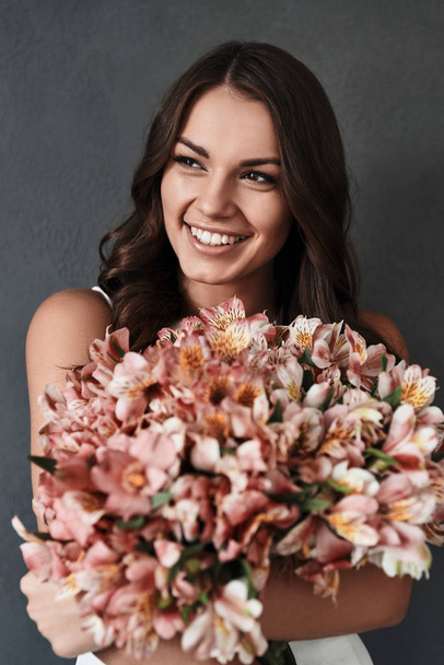 young woman with bunch of flowers - Фото, зображення