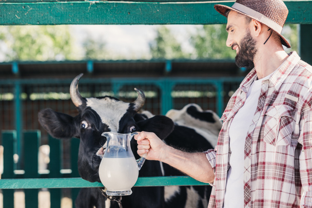 agricultor con leche fresca en establo
 - Foto, Imagen
