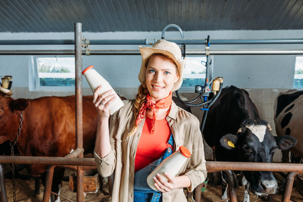 farmer with fresh milk in stall - Foto, afbeelding