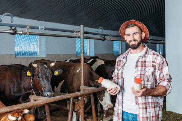 agricultor con leche fresca en establo
 - Foto, Imagen