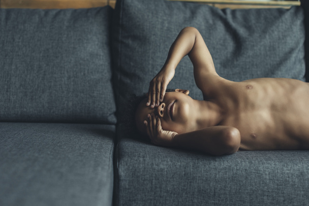 petit enfant torse nu jouant sur le canapé
 - Photo, image