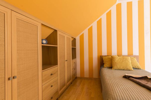 小さなベッドで白とオレンジ色のベッドルーム - 写真・画像