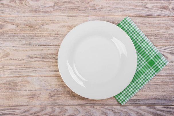 Empty plate with napkin on grey wooden table - 写真・画像