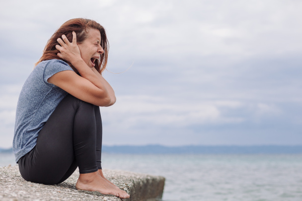 Vrouw alleen en depressief schreeuwen op de brug - Foto, afbeelding