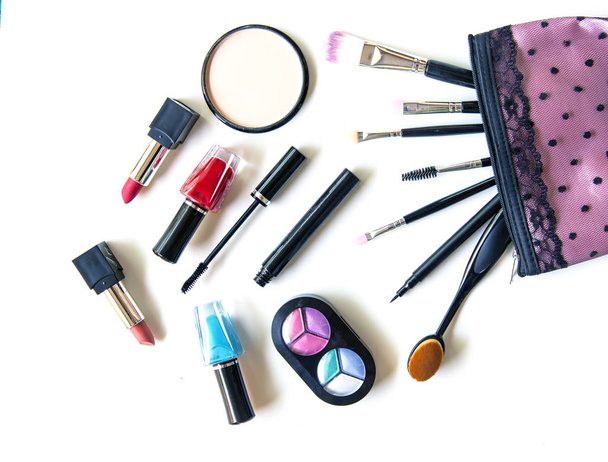Cosmetica en mode achtergrond met make-up artiest objecten: eye shadows, lippenstift, mascara, eyeliner, concealer, nagellak. Levensstijl Concept - Foto, afbeelding