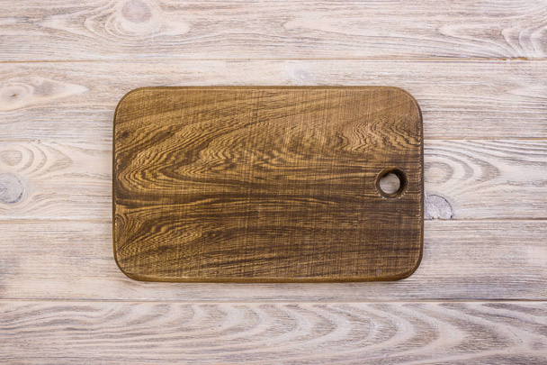 Cutting board on the wooden background. Toned photo. - Фото, зображення