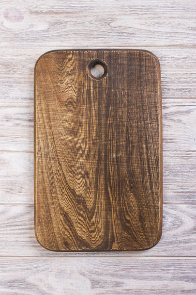 Cutting board on white wooden table, top view - Fotoğraf, Görsel