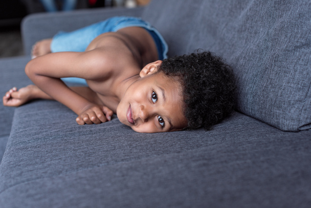 Hemdloses kleines Kind spielt auf dem Sofa - Foto, Bild