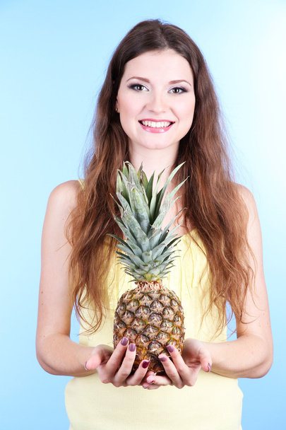 Beautiful woman with pineapple on blue background - Foto, Imagen