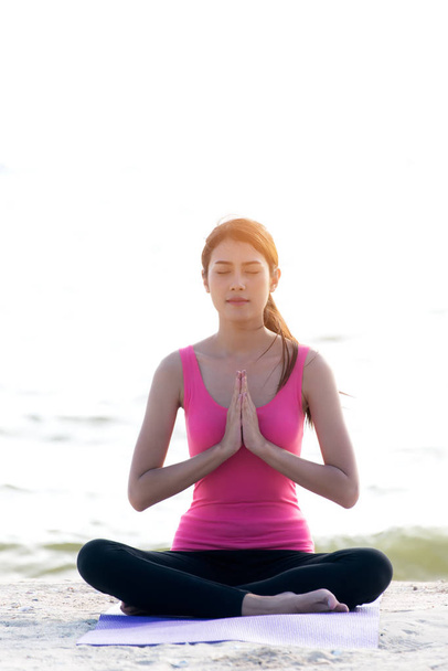 Healthy young woman lifestyle exercising vital meditate and  practicing yoga at seashore, nature background.  Healthy Concept. - Photo, image