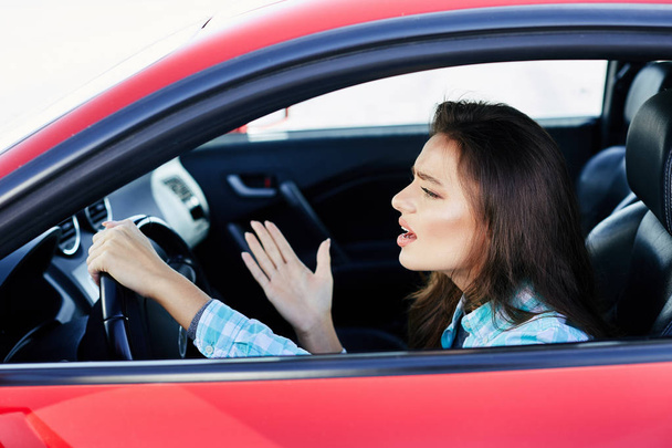 mujer estresada conduciendo coche rojo
 - Foto, Imagen