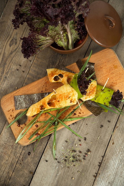 Σνακ τυρί με τόφου, πράσινο πιπέρι, φύλλα nori σε ένα ξύλινο δίσκο - Φωτογραφία, εικόνα