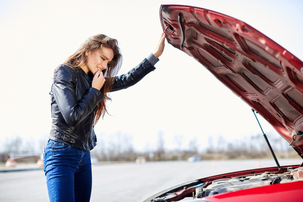 женщина заглядывает внутрь сломанной машины
 - Фото, изображение