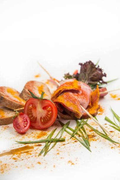 koude gekookte varkensvlees met tomaten op een witte achtergrond - Foto, afbeelding