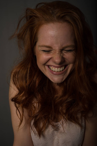 Portrait of a young, beautiful, red-haired woman who laughs - Photo, Image