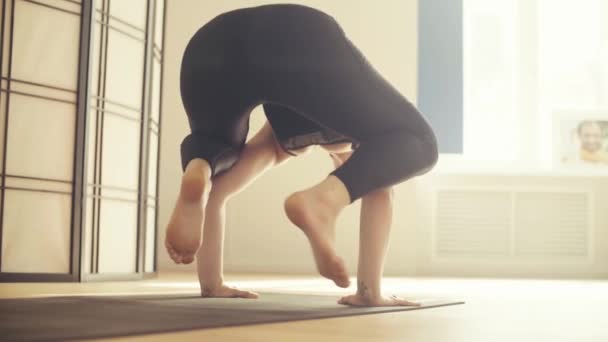 A young woman performing yoga-asanas in the hall. - Filmmaterial, Video