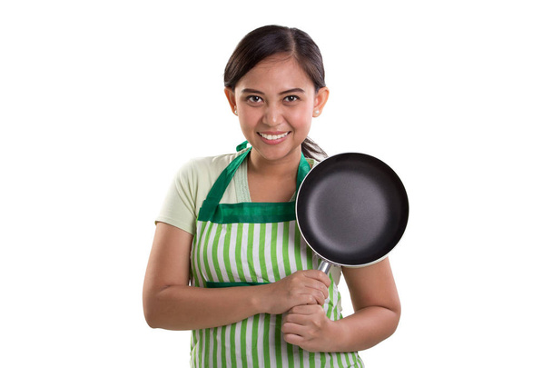 Μαγείρεμα κυρία χαμογελά στη φωτογραφική μηχανή, θέτοντας wih της τηγάνι, απομονώνονται σε λευκό - Φωτογραφία, εικόνα