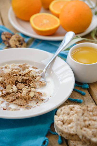 Desayuno saludable, fruta, copos de maíz, leche y jugo de naranja en la mesa de madera
 - Foto, Imagen