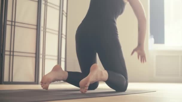 eine junge Frau führt Yoga-Asanas in der Halle vor. - Filmmaterial, Video