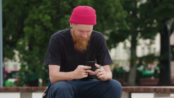 Hipster rudowłosej się Smartfone w dłoni - Materiał filmowy, wideo