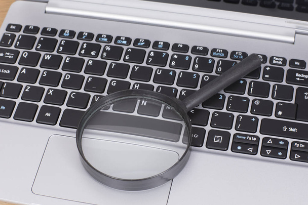 Small round magnifying glass on a laptop - Foto, Imagem