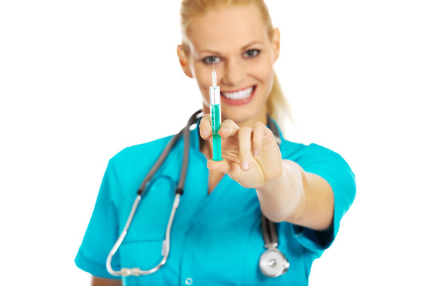 Smiling female doctor or nurse with stethoscope holding syringe - Valokuva, kuva