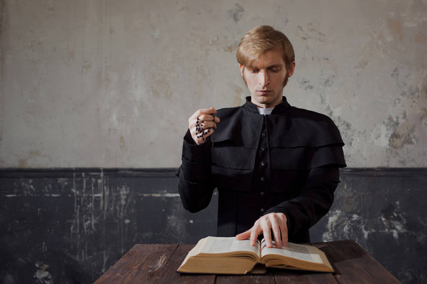 Portrait of handsome young catholic priest praying to God. - Photo, image