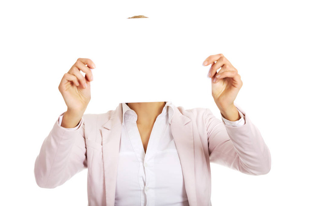 Geschäftsfrau bedeckt Gesicht mit leerem Papierblatt - Foto, Bild