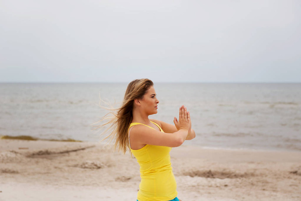 Молода жінка, роблячи вправи йоги на пляжі - Фото, зображення
