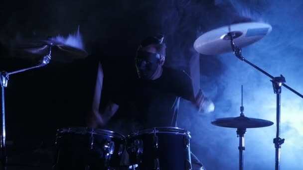 The drummer in mask plays the drum set on the stage. Shot in a slow motion. Music video punk, heavy metal or rock group. - Footage, Video