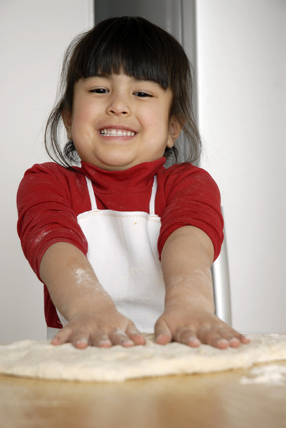 Little girl cooking a pizza in a kitchen.Little kid in a kitchen. - Foto, Imagen