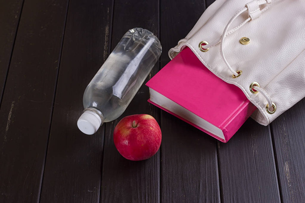 White leather backpack, pink book, bottle of water - Photo, Image