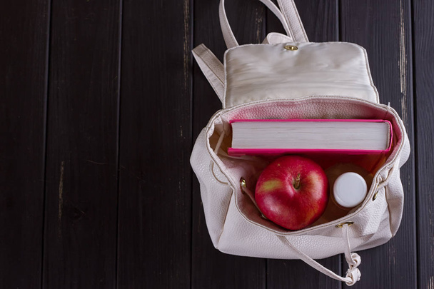 Beyaz Deri sırt çantası, pembe kitap, şişe suyu - Fotoğraf, Görsel