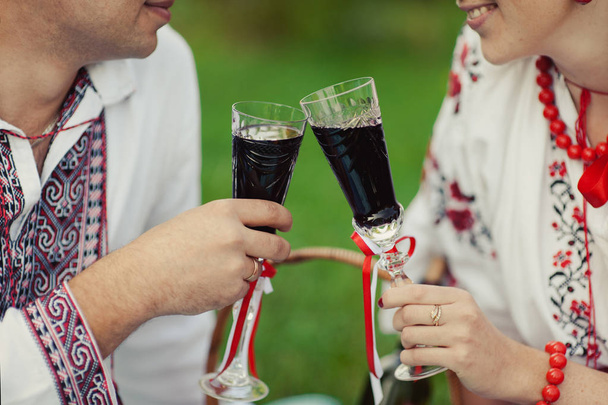 Ζευγάρι σε ένα πικνίκ ποτά σε ποτήρια κρασιού - Φωτογραφία, εικόνα