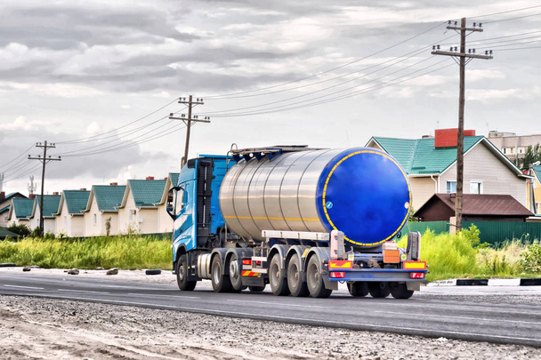 Camión con petrolero de cromo en una gran carretera pavimentada
 - Foto, Imagen