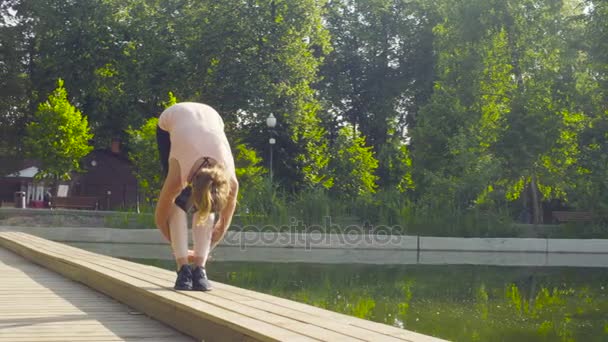 jonge vrouw doet yoga oefeningen in het park - Video