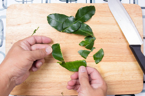 Chef triturar hojas de lima kaffir a mano
. - Foto, Imagen