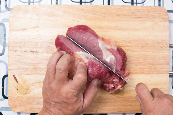 Шеф-кухар ріже яловичину перед приготуванням
  - Фото, зображення