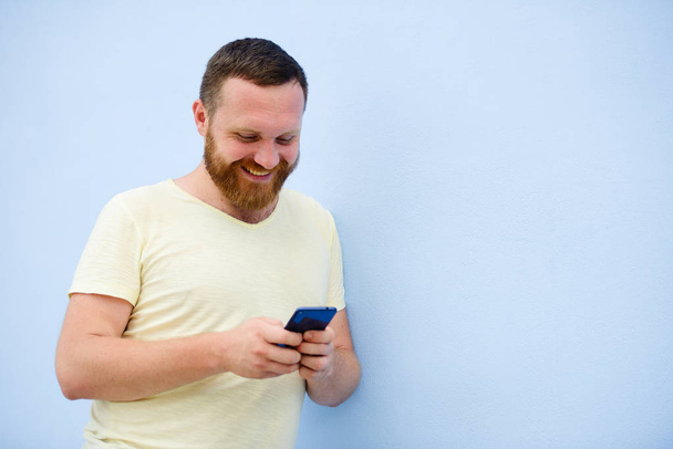 Un hombre hace rostros en un teléfono divertido y humorístico hace rostros serios, una compañía de publicidad
 - Foto, Imagen
