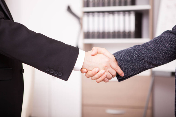 Primer plano de los socios comerciales estrechando la mano en la oficina
 - Foto, imagen