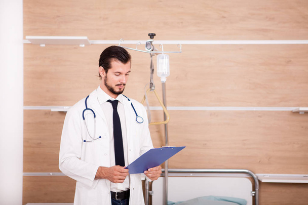 Doctor holding a folder in hands with stethoscope arround his ne - Foto, Bild