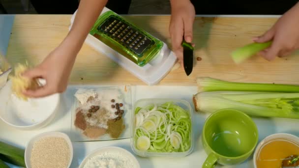 Frauenhände hacken den Sellerie und schieben den Käse in einen Teller - Filmmaterial, Video
