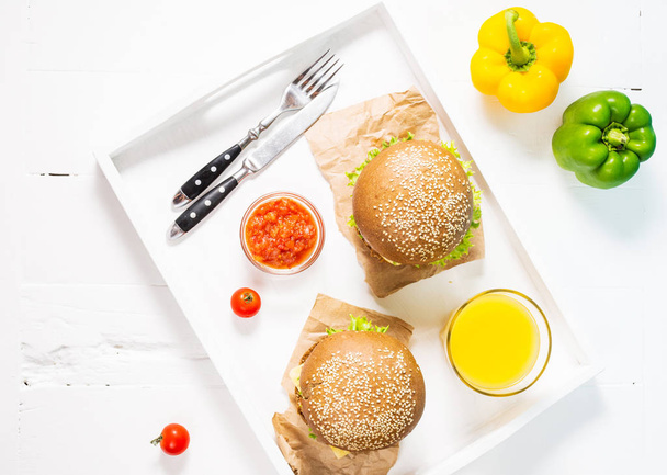 白色トレイにてジュースの新鮮な自家製ハンバーガー - 写真・画像